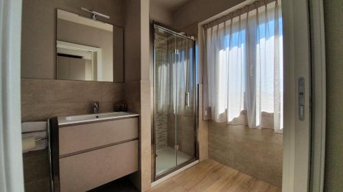 a bathroom with a shower and a sink and a mirror at Appartamenti Moonlight in Seriate