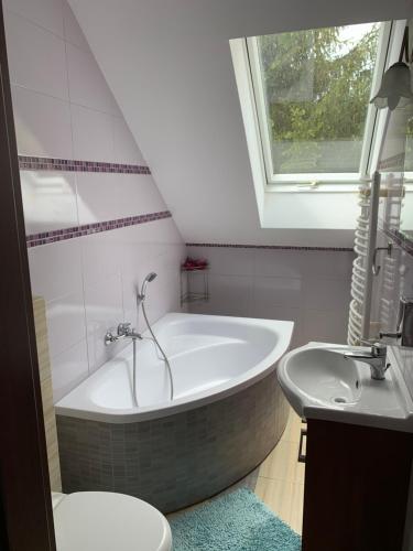 a bathroom with a tub and a toilet and a sink at Dom nad jeziorem Mazury pomost segment 1 in Kozin