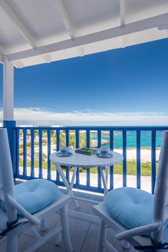 a table and chairs on a balcony with the ocean at Aphrodite by Akroploro in Pollonia