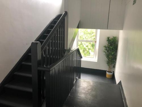 a staircase with a black railing and a window at Premier Apartment C in Broxburn