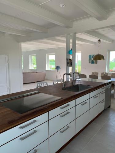 a kitchen with a sink and a living room at Villa Baldringe in Ystad