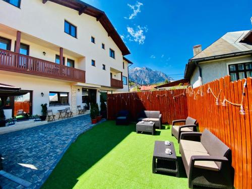 a backyard with a fence and some chairs and tables at CASA ANKELI in Buşteni