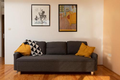 a living room with a gray couch with yellow pillows at Waterfront Roko in Podgora