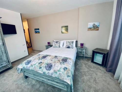 a bedroom with a bed and a tv in it at CASA ANKELI in Buşteni