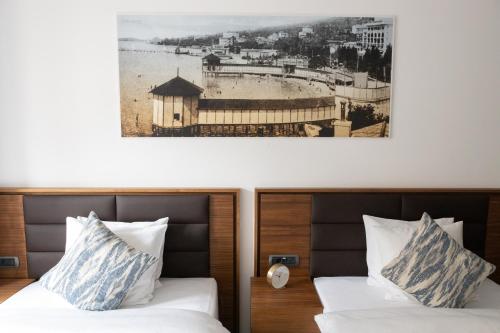 two beds in a hotel room with a picture on the wall at Zabjak5 in Ljubljana