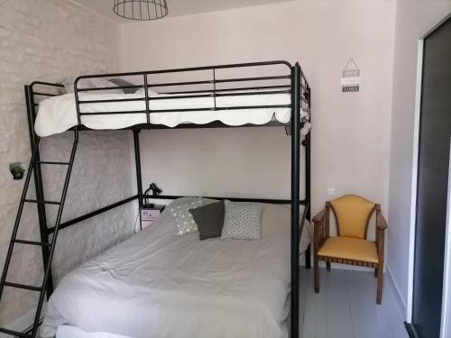 - une chambre avec des lits superposés et une chaise dans l'établissement La croix landolle, à Châteaubernard