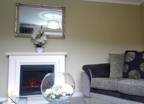 a living room with a couch and a vase on a table at Mary Naoise Holiday Home by Trident Holiday Homes in Lettermacaward