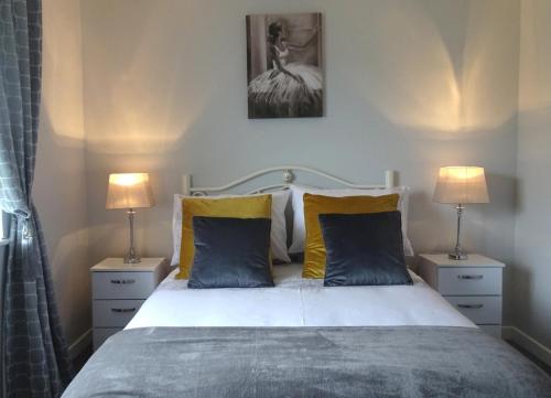 a bedroom with a large bed with two lamps at Mary Naoise Holiday Home in Lettermacaward