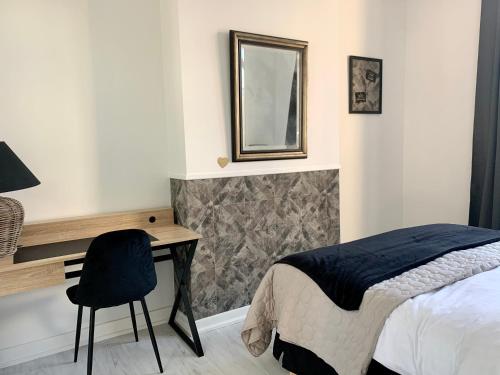 una camera con letto, scrivania e specchio di A & V Appart'hôtel a Lille