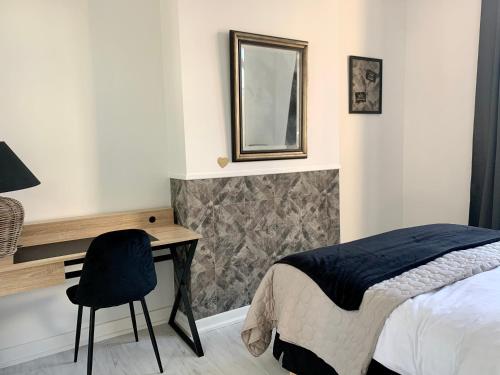 une chambre avec un lit, un bureau et un miroir dans l'établissement A & V Appart'hôtel, à Lille
