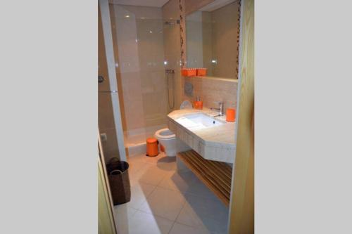 ein Bad mit einem Waschbecken und einem WC in der Unterkunft Moradia Fantástica com Piscina a 5 min da Praia in Monte Gordo