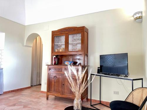 a living room with a tv and a wooden cabinet at La Casa Grande di Pantelleria in Pantelleria