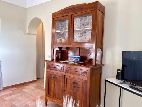 a large wooden cabinet in a room with a television at La Casa Grande di Pantelleria in Pantelleria