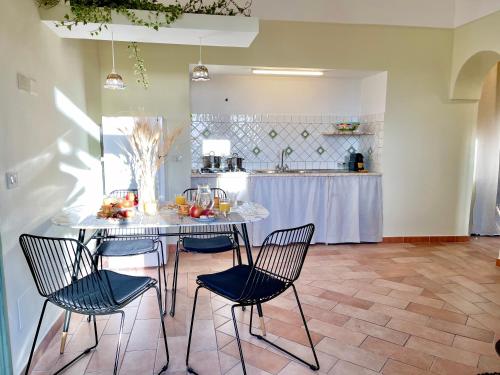 a kitchen with a table with chairs and a counter at La Casa Grande di Pantelleria in Pantelleria