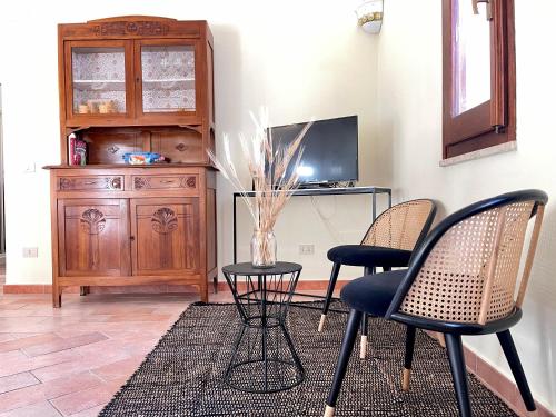 a living room with two chairs and a table and a tv at La Casa Grande di Pantelleria in Pantelleria