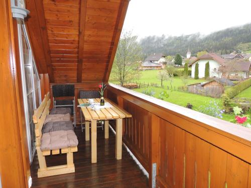 a balcony with a table and chairs and a window at Penthouse Aineckblick in Sankt Margarethen im Lungau