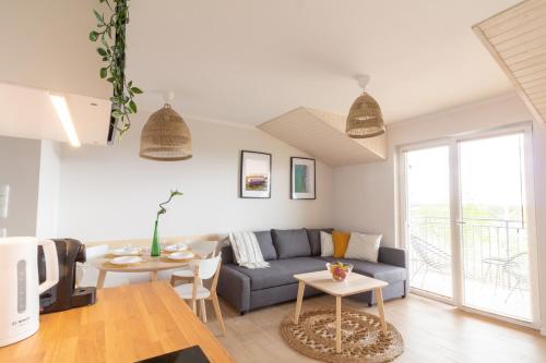 MorzeZatoka - apartamenty Władysławowo في فواديسوافوفو: غرفة معيشة بها أريكة وطاولة