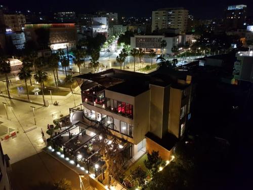 a building with lights in a city at night at Main square apartment in Durrës