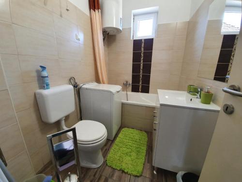 a small bathroom with a toilet and a sink at Flamingo Apartment in Sárvár