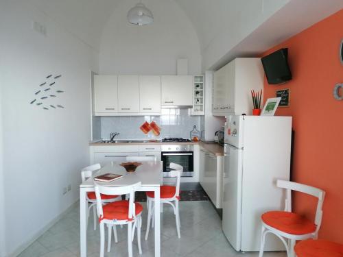 a kitchen with a white refrigerator and a table and chairs at Villa Mirella Sea View Apartments in Positano