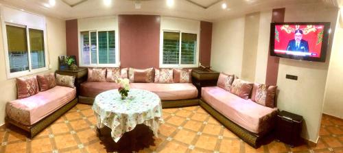 a large living room with a couch and a table at Villa ain soltan in Imouzzer du Kandar