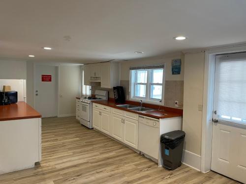 a kitchen with white cabinets and a sink and a window at Wildwood Inn Hotel Travelodge Beach & Boardwalk in Wildwood