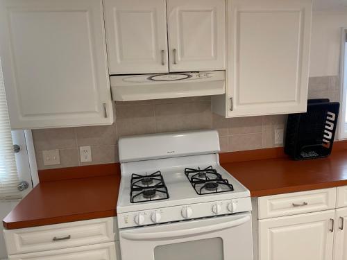 a kitchen with a white stove and white cabinets at Wildwood Inn Hotel Travelodge Beach & Boardwalk in Wildwood
