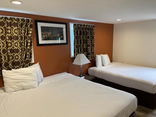 a hotel room with two beds and a window at Wildwood Inn Hotel Travelodge Beach & Boardwalk in Wildwood