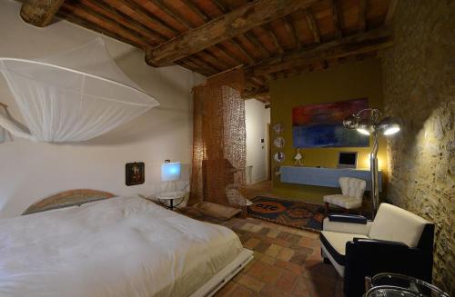 a bedroom with a large bed and a living room at Morelliana4Rooms in Scansano