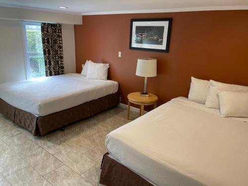 a hotel room with two beds and a window at Wildwood Inn Hotel Travelodge Beach & Boardwalk in Wildwood