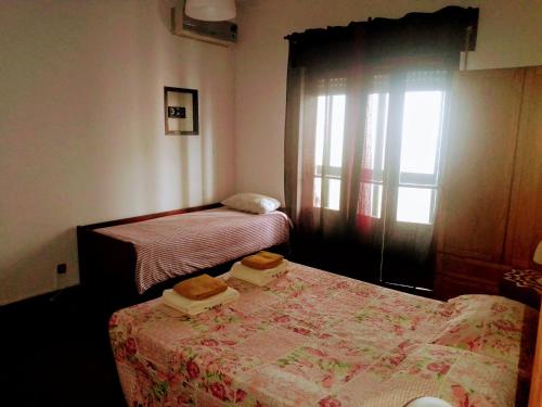 a small bedroom with two beds and a window at Alojamento Local, Cantinho Verde in Corroios