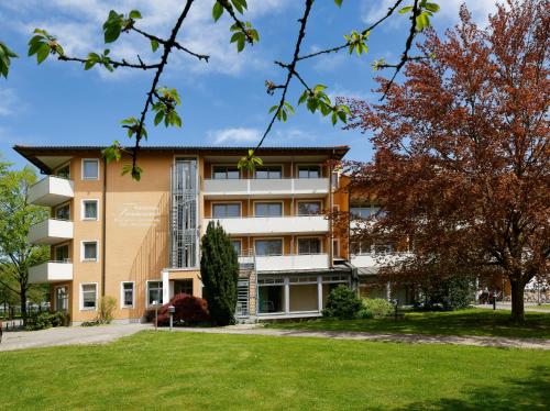 an apartment building with a lawn in front of it at Kurpension Freudenstein in Bad Füssing