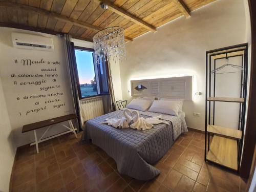 1 dormitorio con 1 cama con lámpara de araña en Villa Proserpina, en Castel Ritaldi