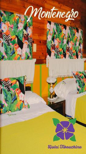 a room with two beds and a sign on the wall at Hotel Tibouchina in Filandia