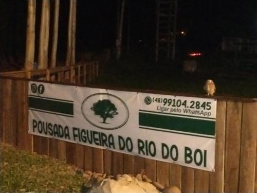a sign on a fence with a tree on it at Figueira do Rio do Boi Com Hidromassagem in Praia Grande