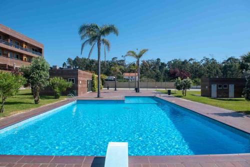 a large swimming pool in a building with palm trees at Charming Apartment in Marmoiral