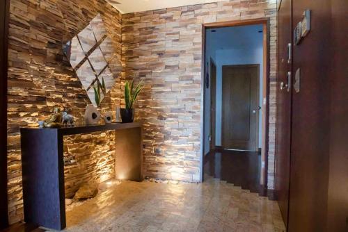 a hallway with a stone wall with a table and a door at Charming Apartment in Marmoiral