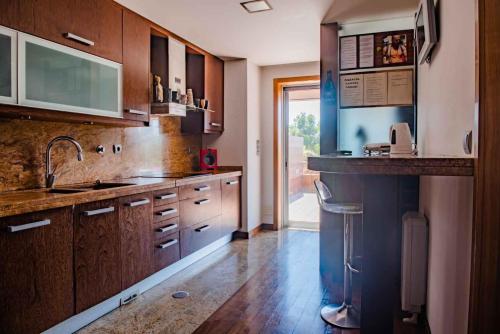 a large kitchen with wooden cabinets and a sink at Charming Apartment in Marmoiral
