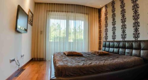 a bedroom with a large bed and a leather couch at Charming Apartment in Marmoiral