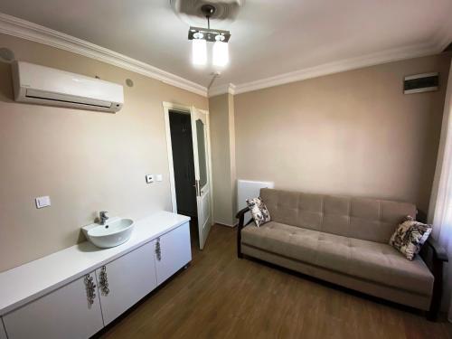 een woonkamer met een bank en een wastafel bij Mai Otel Cunda in Ayvalık