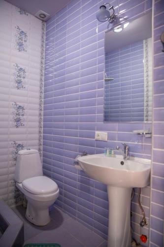 a blue tiled bathroom with a toilet and a sink at Family Hotel Kolorit Old Tbilisi in Tbilisi City