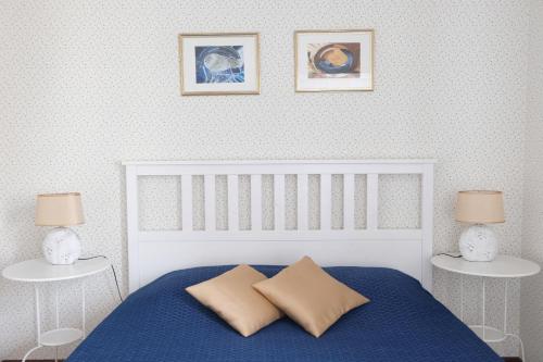 een slaapkamer met een blauw bed en 2 tafels bij Downtown Apartment in Pärnu