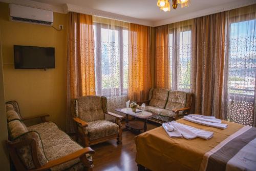 um quarto de hotel com uma cama, uma mesa e cadeiras em Family Hotel Kolorit Old Tbilisi em Tbilisi