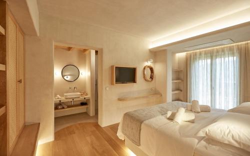 a bedroom with a large bed and a bathroom at Sunrise Garden Hills in Makrirrákhi