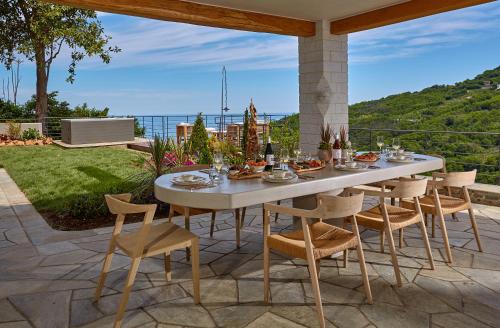 a table and chairs on a patio with a view at Sunrise Garden Hills in Makrirrákhi