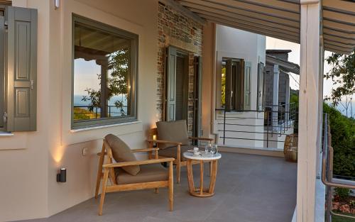 a patio with a table and chairs on a porch at Sunrise Garden Hills in Makrirrákhi