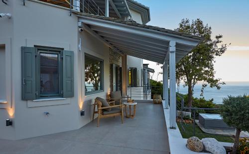 a house with a patio with a view of the ocean at Sunrise Garden Hills in Makrirrákhi