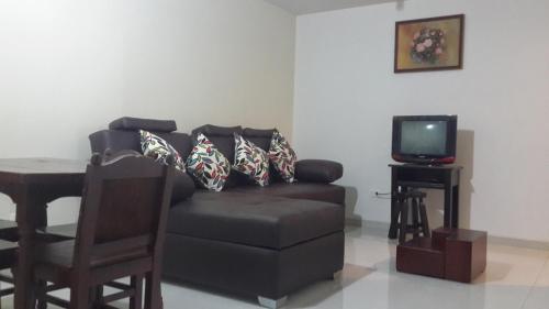 a living room with a couch and a television at Apartamentos Edificio Diamante in Paipa