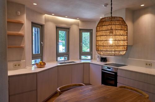 a kitchen with a table and a pendant light at Sunrise Garden Hills in Makrirrákhi