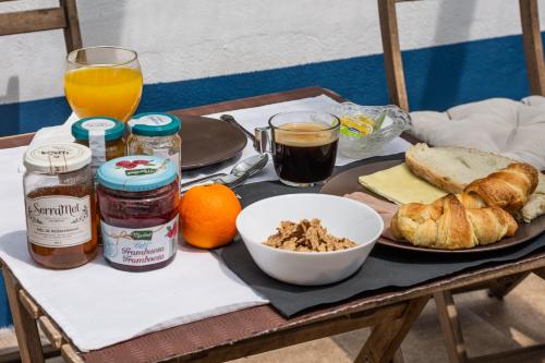 a breakfast table with a plate of food and orange juice at MontePico in Grândola